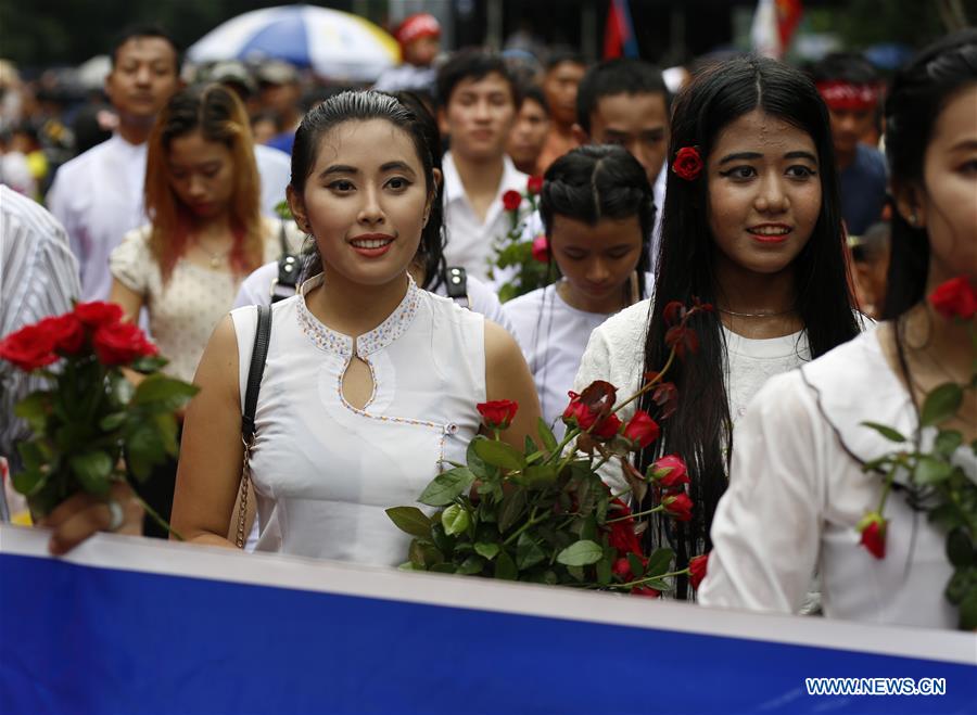 People hold flowers as they wait outside the Martyrs' Mausoleum to pay homage during the 69th Martyrs' Day ceremony in Yangon, Myanmar, July 19, 2016. 