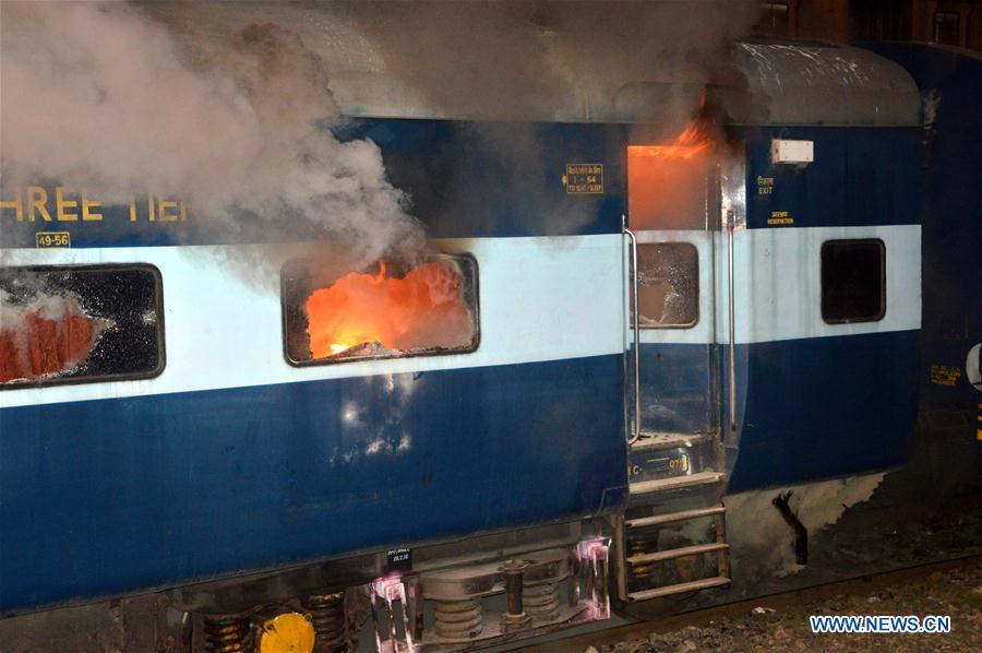 Police try to put out the fire on a train coach at Rajendra Nagar Terminal in Patna, India, on July 22, 2016. 