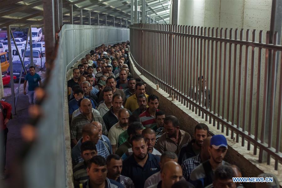 Palestinian labourers, working in Israel, make their way to their workplaces, through the main Israeli terminal in the West Bank city of Bethlehem, on July 24, 2016.