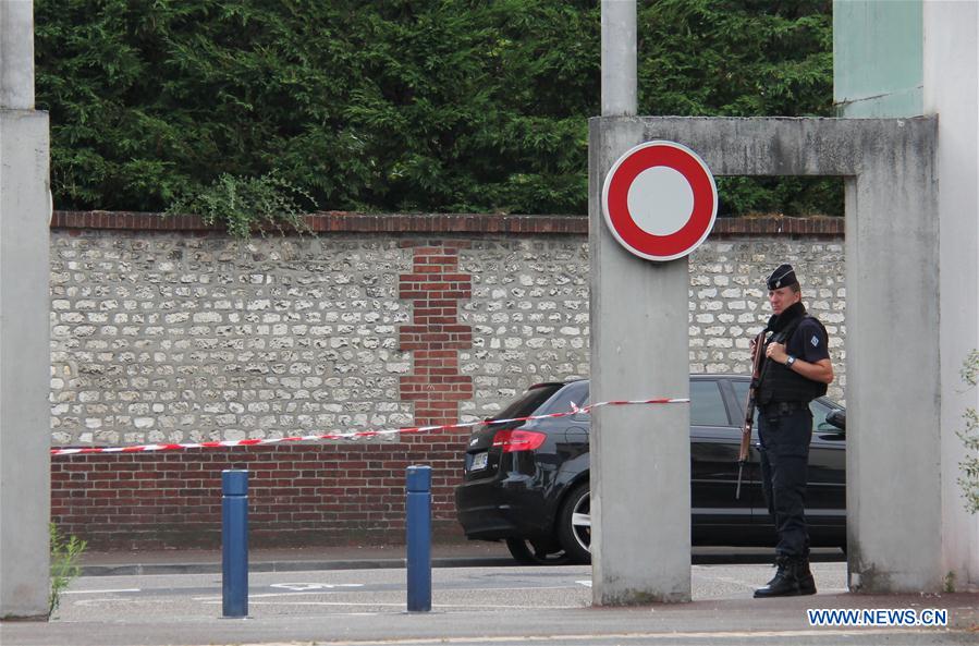 Police stand guard near the church where a priest was killed in Saint-Etienne du Rouvray, France on July 26, 2016.
