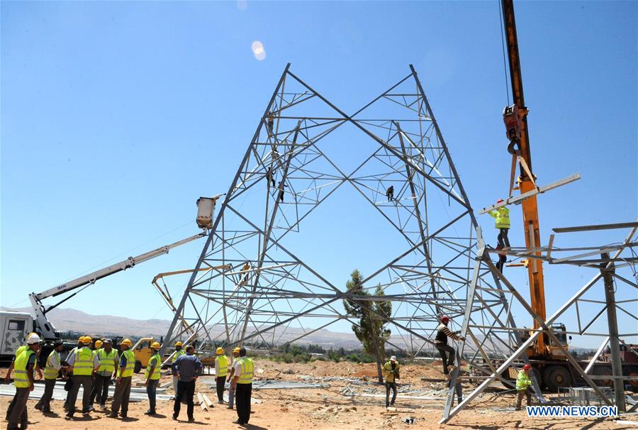 Electricity workers fix high-voltage power lines in Dimas, countryside of Damascus, capital of Syria, on July 27, 2016.