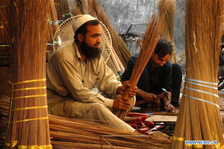 A man shows handmade fans at a shop in northwest Pakistan's Peshawar, Aug. 6, 2016.