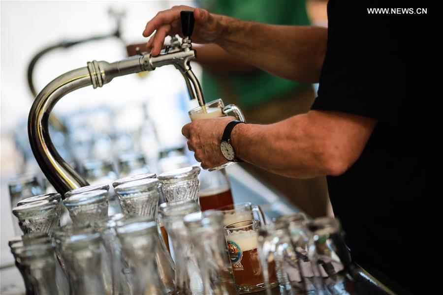 A staff member works at a beer stand during the 20th Berlin Beer Festival at the Karl Marx Avenue in Berlin, Germany, on Aug. 6, 2016. 