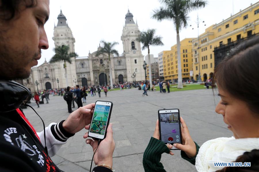 Two youngsters play 'Pokemon Go' on their smartphones at Plaza Mayor in Lima, capital of Peru, on Aug. 7, 2016.