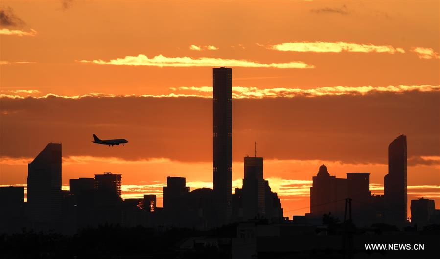 An airplane flies over Manhattan as the sun sets in New York, the United States, Sept. 7, 2016.