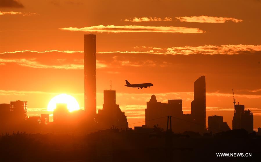 An airplane flies over Manhattan as the sun sets in New York, the United States, Sept. 7, 2016.