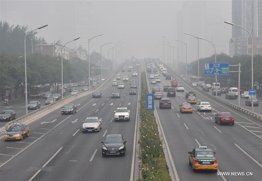 Vehicles run on a smog-shrouded road in Beijing, capital of China, Oct. 14, 2016.