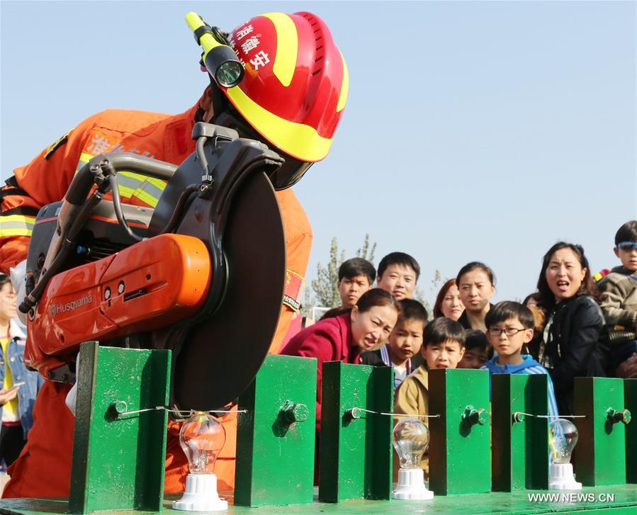 Students and their parents try fire extinguishers under the guidance of firefighters during a fire fighting public event in Huaibei, east China's Anhui Province, Nov. 5, 2016