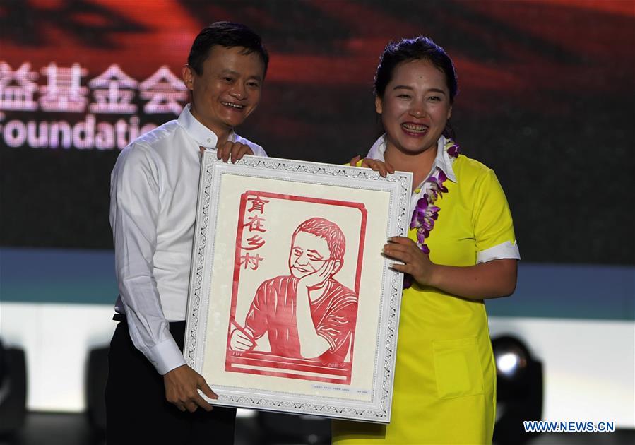 Jack Ma (L) receives a present of his portrait papercutting from Feng Haiyan, a winner of the Jack Ma Rural Teachers Award, in Sanya, a tourism resort in south China's Hainan Province, on Jan. 5, 2017. The awarding ceremony of the Jack Ma Rural Teachers Award was held on Thursday, with 100 rural teachers winning the award of 100,000 yuan (14,522 U.S. dollars) respectively. (Xinhua/Yang Guanyu) 