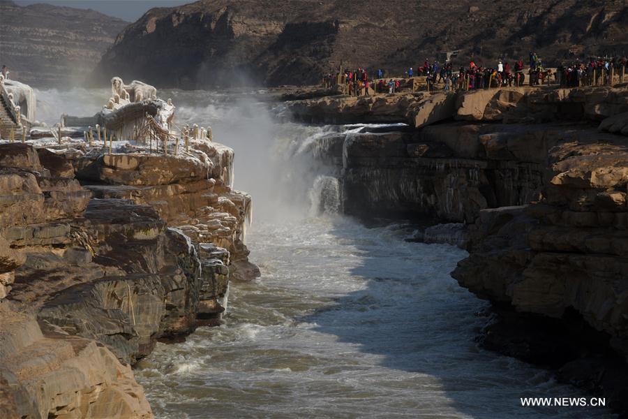 A performer plays the waist drum by the Hukou Waterfall on the Yellow River, which is located on the border area between north China's Shanxi and northwest China's Shaanxi provinces, Jan. 14, 2017.