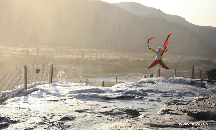 A performer plays the waist drum by the Hukou Waterfall on the Yellow River, which is located on the border area between north China's Shanxi and northwest China's Shaanxi provinces, Jan. 14, 2017. A performer plays the waist drum by the Hukou Waterfall on the Yellow River, which is located on the border area between north China's Shanxi and northwest China's Shaanxi provinces, Jan. 14, 2017.