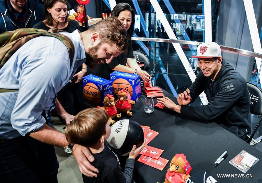 Brooklyn Nets guard Jeremy Lin (R) interacts with a little boy at a Chinese New Year celebration at the NBA store on Manhattan 5th Avenue, New York City, the United States, on Jan. 24, 2017. Brooklyn Nets guard Jeremy Lin said Monday he expected to be back to action in 3-5 weeks from his left hamstring injury. (Xinhua/Li Rui) 