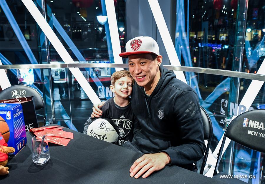 Brooklyn Nets guard Jeremy Lin (R) poses for photo with a little boy at a Chinese New Year celebration at the NBA store on Manhattan 5th Avenue, New York City, the United States, on Jan. 24, 2017. Brooklyn Nets guard Jeremy Lin said Monday he expected to be back to action in 3-5 weeks from his left hamstring injury. (Xinhua/Li Rui) 