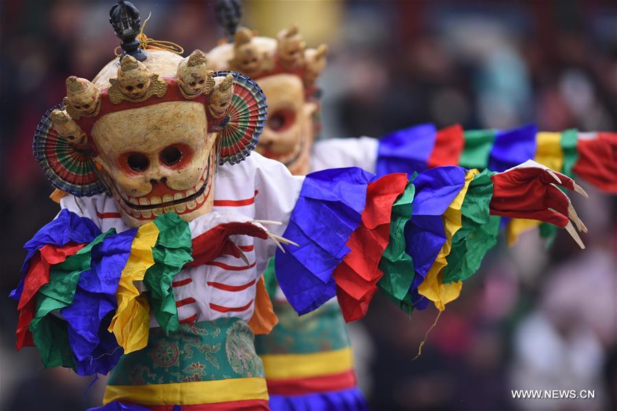 A monk performs 'Tiaoqian', a masked religious dance with a history of nearly 300 years, at the Kumbum Monastery in Huangzhong County, northwest China's Qinghai Province, Feb. 10, 2017. 