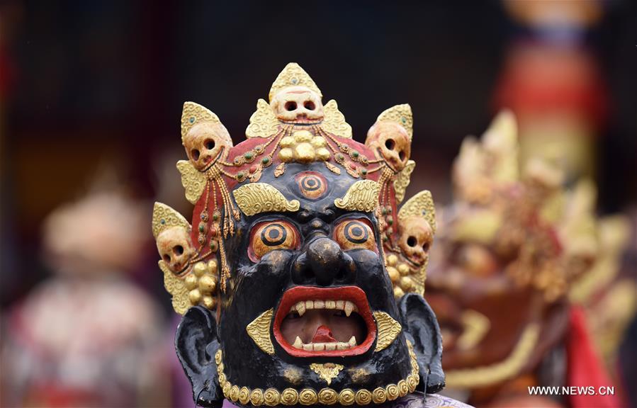 A monk performs 'Tiaoqian', a masked religious dance with a history of nearly 300 years, at the Kumbum Monastery in Huangzhong County, northwest China's Qinghai Province, Feb. 10, 2017. 
