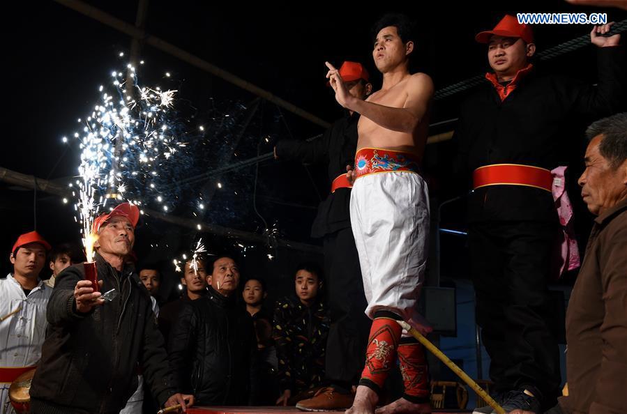 A villager performs 'firework eating' in Huadong Village, Putian City of southeast China's Fujian Province, Feb. 12, 2017.