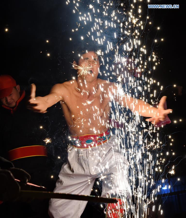 A villager performs 'firework eating' in Huadong Village, Putian City of southeast China's Fujian Province, Feb. 12, 2017. 