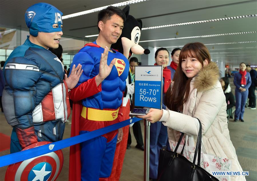 Staff dressed as cartoon characters farewell passengers of flight MF849 at the Fuzhou International Airport in Fuzhou, capital of southeast China's Fujian Province, Feb. 15, 2017. MF849, the first direct flight of Xiamen Airlines from Fuzhou to New York, took off here on Wednesday. 