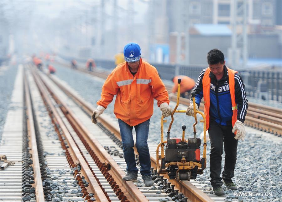 Workers adjust Wuhan-Jiujiang Passenger Railway in Jiujiang, east China's Jiangxi Province, Feb. 15, 2017.