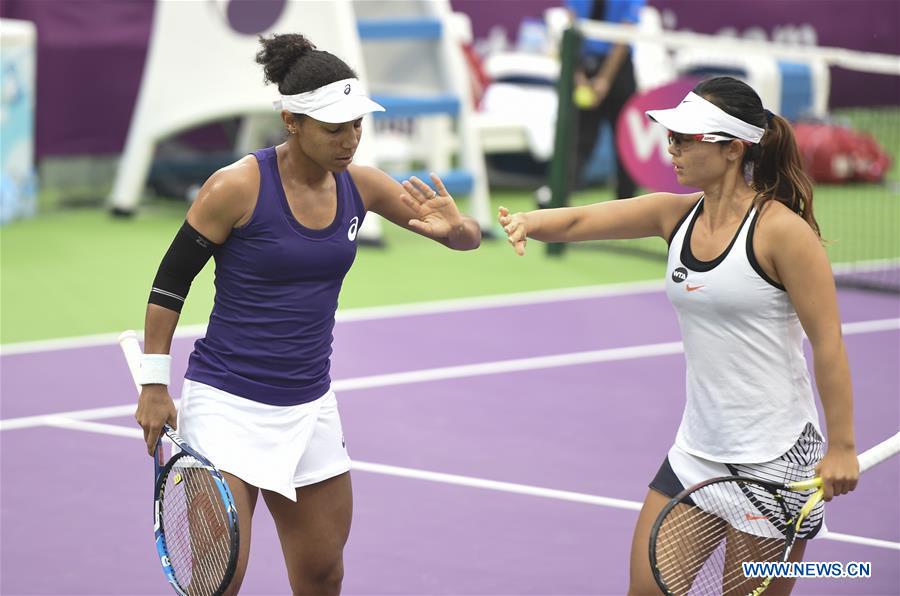 Xu Yifan (R) of China and Raquel Atawo of the United States react during the women's doubles 1st round match against Sania Mirza of India and Barbora Strycova of Czech Republic at WTA Qatar Open 2017 at the International Khalifa Tennis Complex of Doha, Qatar, Feb. 16, 2017. Mirza and Strycova won 2-0. (Xinhua/Nikku) 