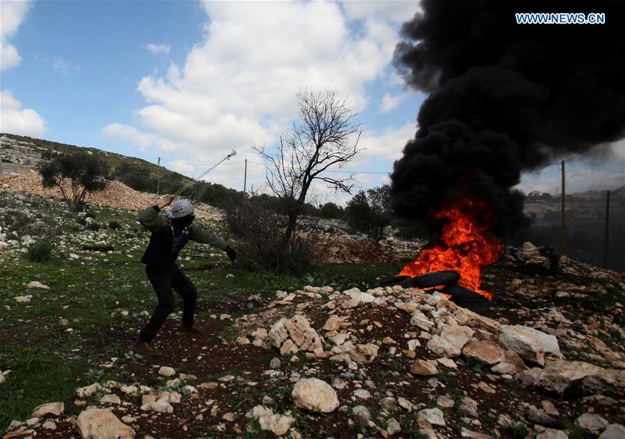 A Palestinian protester hurls a stone at Israeli soldiers during clashes after a protest against the expanding of Jewish settlements in Kufr Qadoom village near the West Bank city of Nablus, on Feb. 17, 2017.
