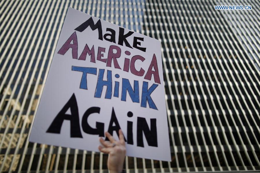 A protester holds up a placard during a protest calling for a general strike against U.S. President Donald Trump in Chicago, the United States, on Feb. 17, 2017. 