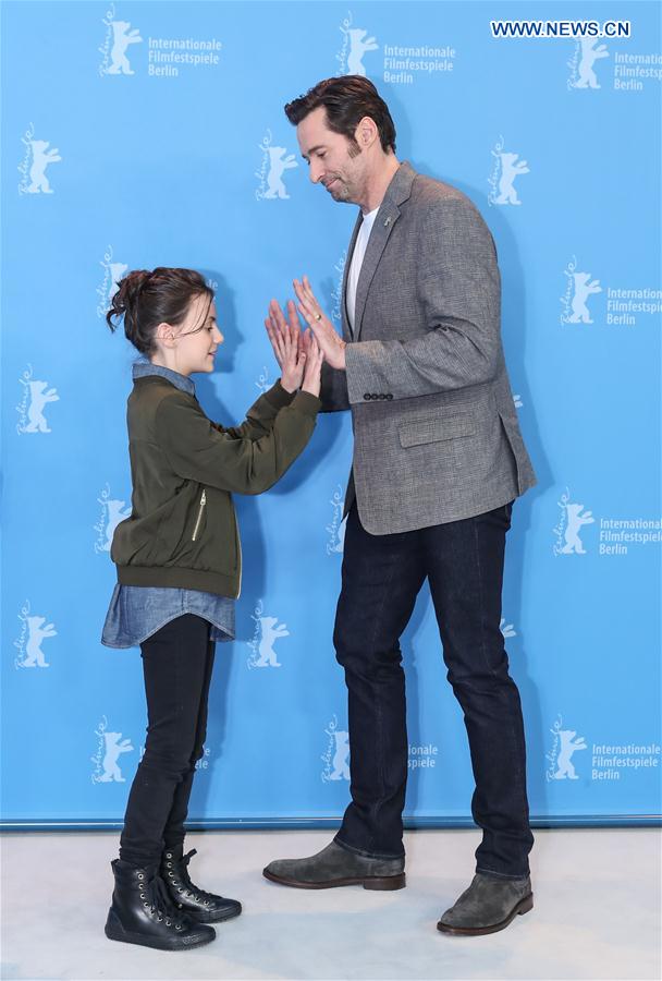 Actor Hugh Jackman (R) and actress Dafne Keen react at a photocall for the film 'Logan' during the 67th Berlinale International Film Festival in Berlin, capital of Germany, on Feb. 17, 2017.