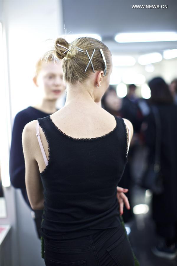 A model waits to change her clothes backstage before ANNAKIKI show during Milan Fashion Week Fall-Winter 2017-18 in Milan, Italy on Feb. 22, 2017.