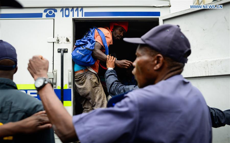 An arrested activist is put into a police vehicle during an anti-immigrant march in Pretoria, South Africa, on Feb. 24, 2017.