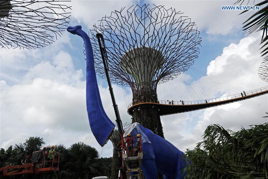Workers install a dinosaur statue for the Children's Festival in the Supertree Grove at Singapore's Gardens by the Bay on Feb. 28, 2017. Workers install a dinosaur statue for the Children's Festival in the Supertree Grove at Singapore's Gardens by the Bay on Feb. 28, 2017.