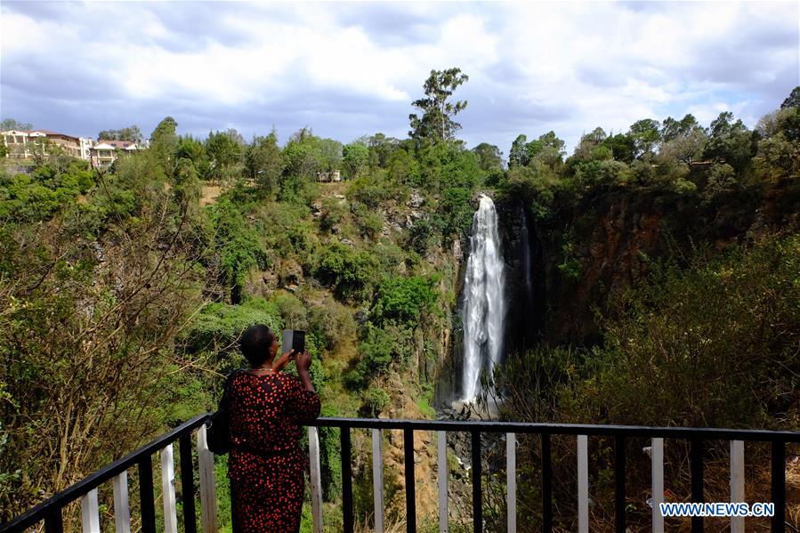 A woman takes a photo of Thomson's falls in Nyahururu, 186 kilometers north of Kenya's capital Nairobi Feb. 28, 2017. The waterfall on a ledge of volcanic rock, discovered by Scottish geologist and naturalist Joseph Thomson in 1883, is a major economic resource for the adjacent town of Nyahururu.