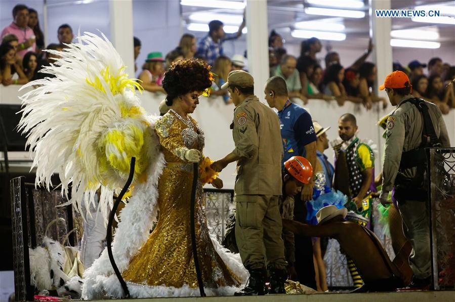 A rescuer helps a wounded person after the collapse of the top of an allegorical car of the samba school Unidos da Tijuca during the Carnival parade as it advanced through the Marques de Sapucai Avenue, in downtown Rio de Janeiro, Brazil, on Feb. 28, 2017. 