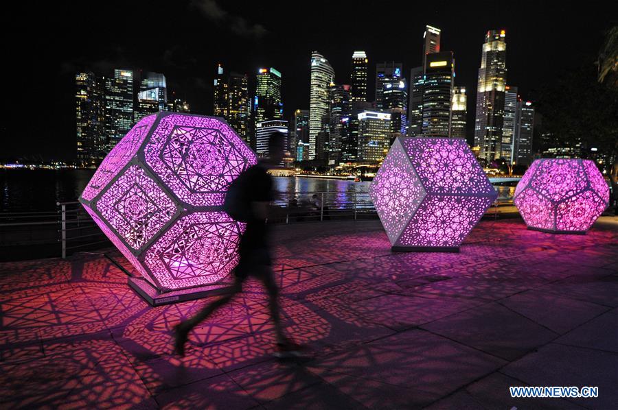 A man runs past a light work at the 'i Light Marina Bay' media preview at Singapore's Marina Bay on March 1, 2017.