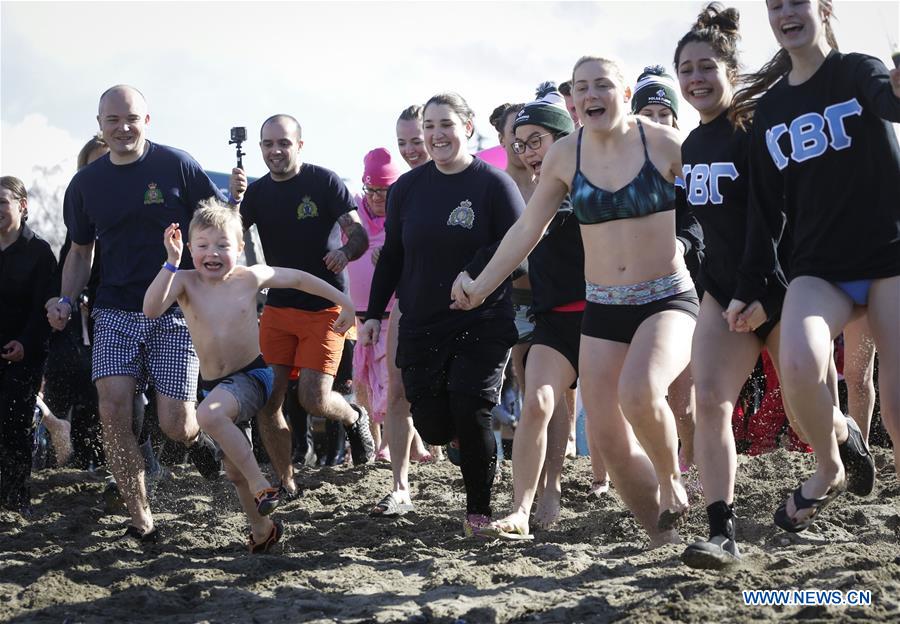 People run towards the chilly water during the Polar Plunge to raise money for Special Olympics at Kitsilano Beach in Vancouver, Canada, March 4, 2017.