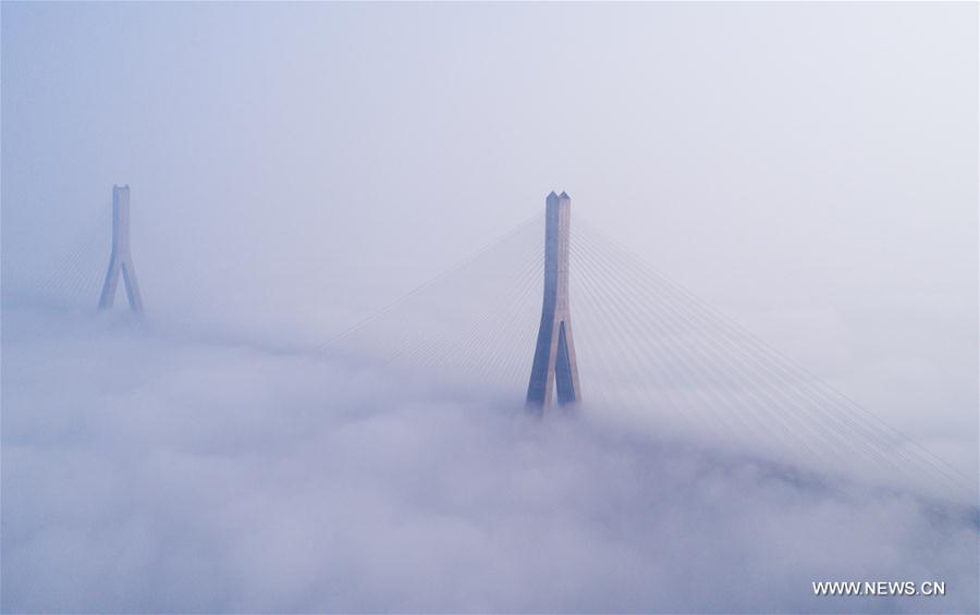 Tianxingzhou Bridge and surrounding buildings are enveloped by heavy fog in Wuhan, capital of central China's Hubei Province, March 7, 2017. 