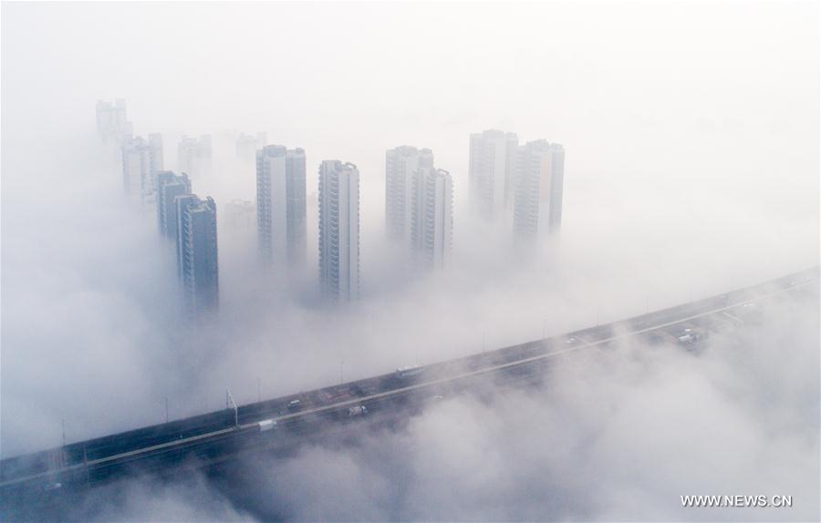 Tianxingzhou Bridge and surrounding buildings are enveloped by heavy fog in Wuhan, capital of central China's Hubei Province, March 7, 2017. 