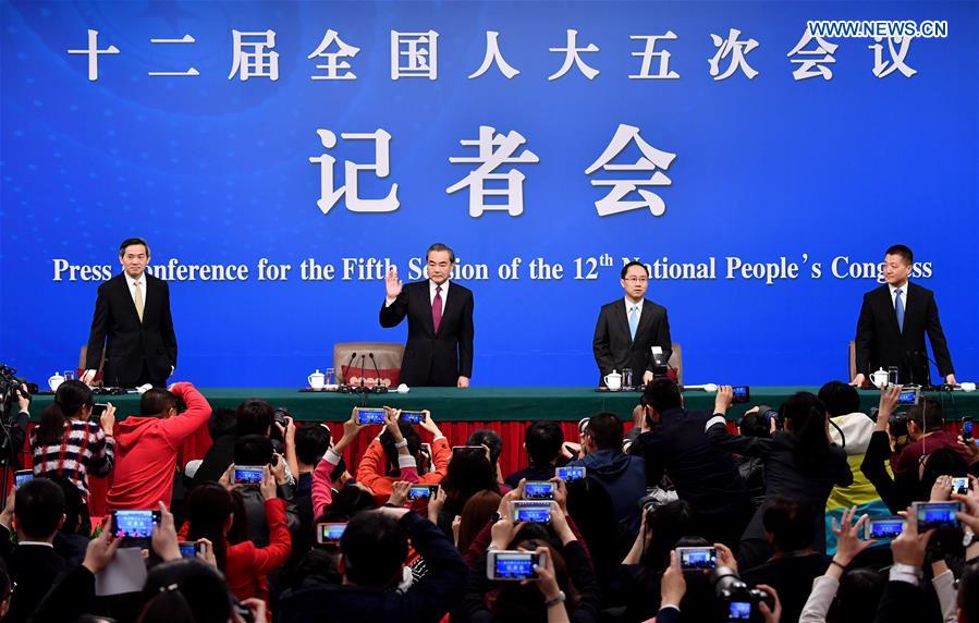 Chinese Foreign Minister Wang Yi (2nd L) waves to media at a press conference on China's foreign policy and foreign relations for the fifth session of the 12th National People's Congress in Beijing, capital of China, March 8, 2017. 