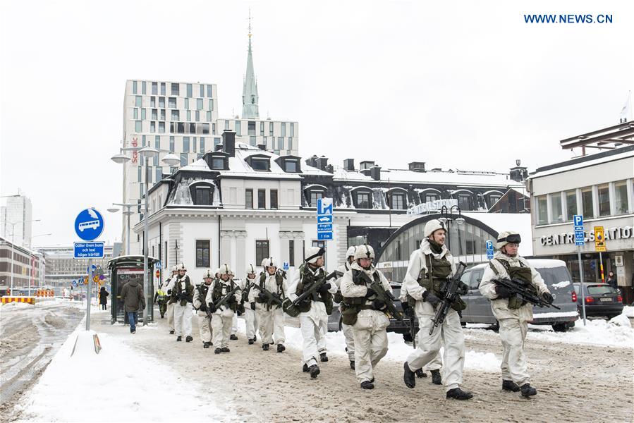 A group of Swedish soldiers and officers equipped with combat gear and weapons march through central Stockholm, capital of Sweden, on March 8, 2017. 