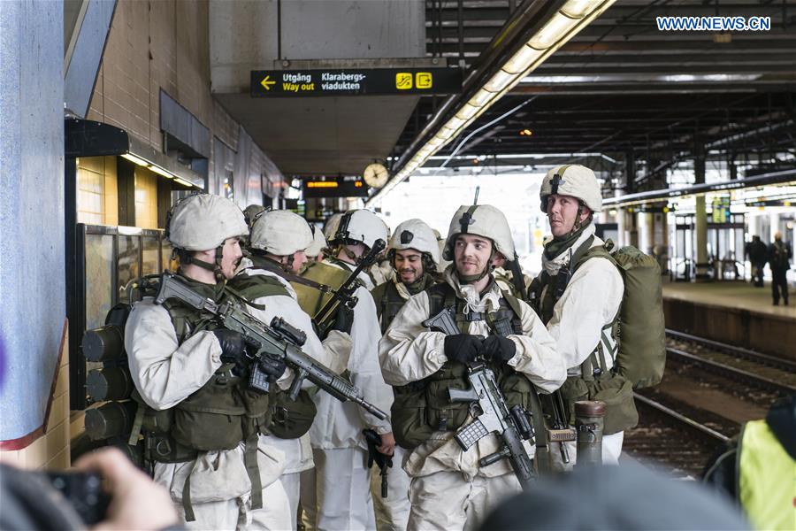 A group of Swedish soldiers and officers equipped with combat gear and weapons wait for a train at a railway station during a march through central Stockholm, capital of Sweden, on March 8, 2017.