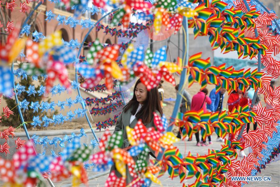 People view the pinwheel decoration in Dalian, northeast China's Liaoning Province, March 11, 2017. 