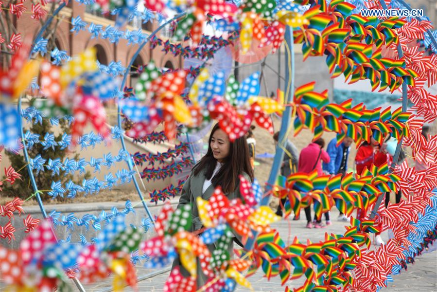 People view the pinwheel decoration in Dalian, northeast China's Liaoning Province, March 11, 2017.