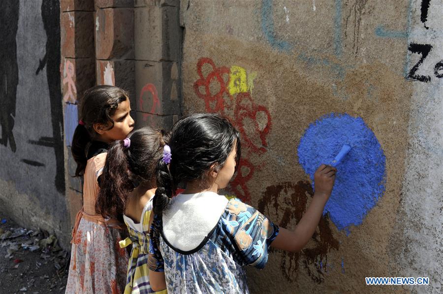 Children paint graffiti on a wall during a campaign in Sanaa, Yemen, on March 15, 2017. A campaign was staged for people to express their wishes for peace and rejection of violence and war by painting graffiti on the walls of Sanaa's streets here on Wednesday. (Xinhua/Mohammed Mohammed) 