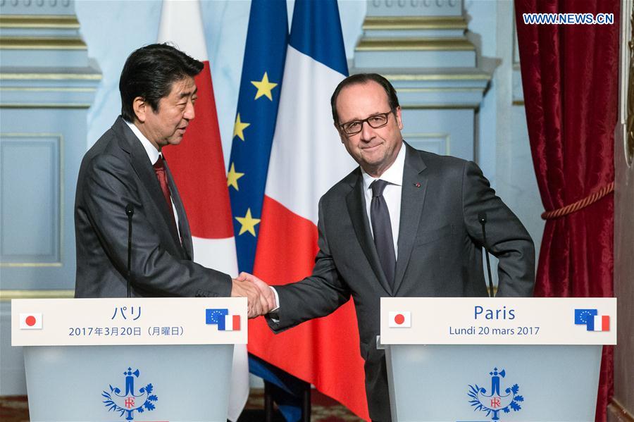 French President Francois Hollande (R) shakes hands with visiting Japanese Prime Minister Shinzo Abe at the Elysee Palace in Paris, France, on March 20, 2017. 
