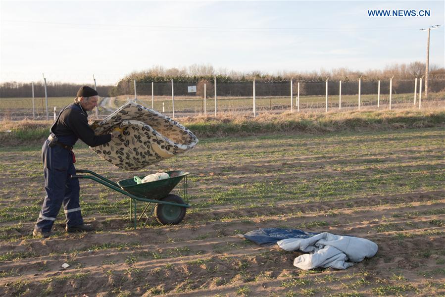 A man collects rubbish left behind by migrants who try to enter Hungary near Kelebia on the Serbian side of the Hungarian-Serbian border, March 20, 2017. 