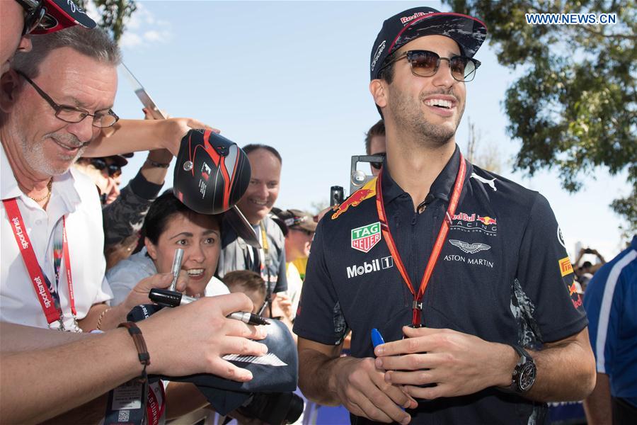 Red Bull Racing Formula One driver Daniel Ricciardo(R) of Australia signs autographs for his fans as he arrives for the third practice session ahead of the Australian Formula One Grand Prix at Albert Park circuit in Melbourne, Australia on March 25, 2017.