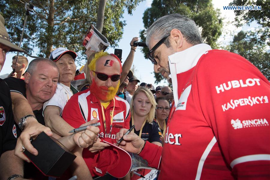 Scuderia Ferrari Formula One team principle Maurizio Arrivabene(R) signs autographs for the fans as he arrives for the third practice session ahead of the Australian Formula One Grand Prix at Albert Park circuit in Melbourne, Australia on March 25, 2017. 