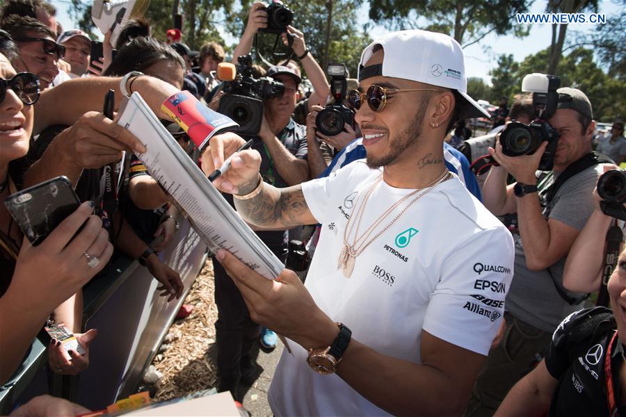 Mercedes AMG Petronas Formula One driver Lewis Hamilton of Britain signs autographs for his fans as he arrives for the third practice session ahead of the Australian Formula One Grand Prix at Albert Park circuit in Melbourne, Australia on March 25, 2017. 