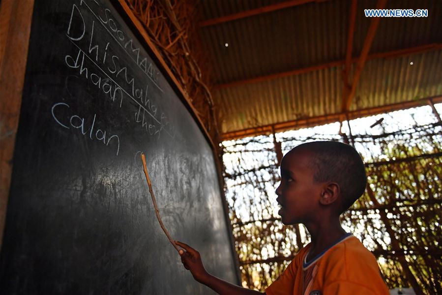 A boy reads what is written on a blackboard in Somali at Kabasa Primary School in Doolow, a border town with Ethiopia, Somalia, on March 21, 2017. 