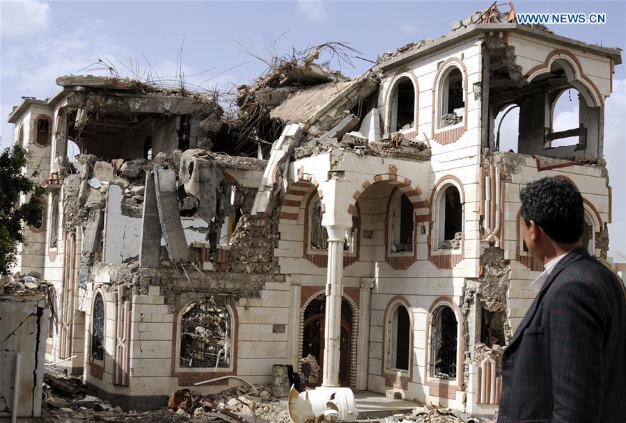 A man looks at the ruins of a building destroyed in airstrikes at the Airport district in Sanaa, capital of Yemen, a day before the second anniversary of the military intervention in Yemen, on March 25, 2017. 
