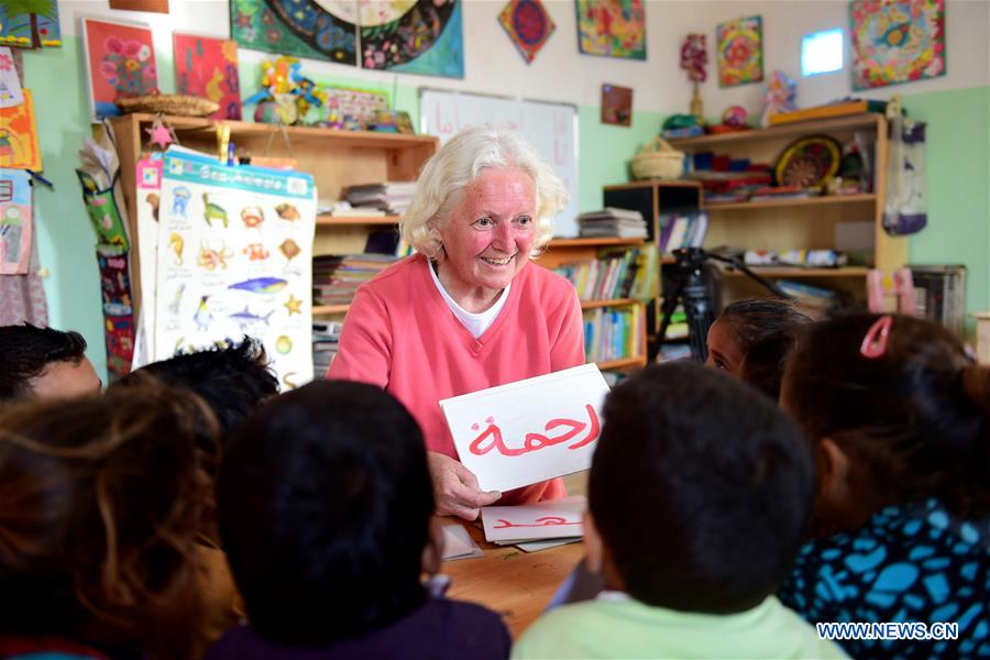 Lady Didi (C) teaches children Arabic at her Nile River School in Ayyat district on the outskirts of Giza Province, about 100 km south of Cairo, capital of Egypt, on March 26, 2017. Diana Sandor, known as Didi, an old Hungarian-born German-raised woman, covered the long distance from West to East six years ago to open her Nile River School as a charitable kindergarten and educational center at the heart of remote, impoverished Baharwa village of Ayyat district on the outskirts of Giza Province, about 100 km south of the Egyptian capital Cairo. Didi said she started building the center 'brick by brick,' through little donations from friends and volunteers around the world and that she is concerned with 'teaching children life,' not just languages and skills. (Xinhua/Zhao Dingzhe) 